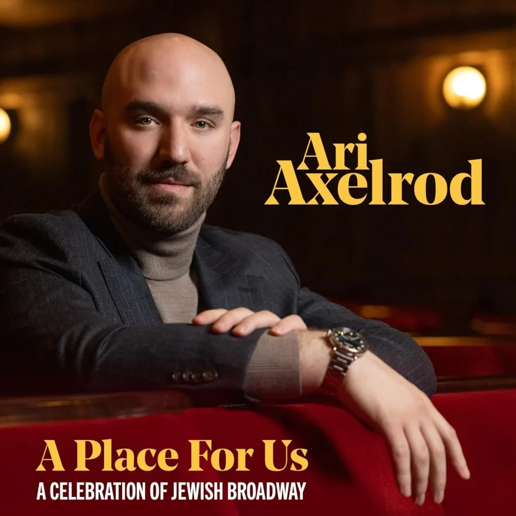Portrait of Ari Axelrod, a bald man with a beard in a dark blazer, leaning on a red velvet surface; text 'Ari Axelrod' and 'A Place For Us' appears on the right side.