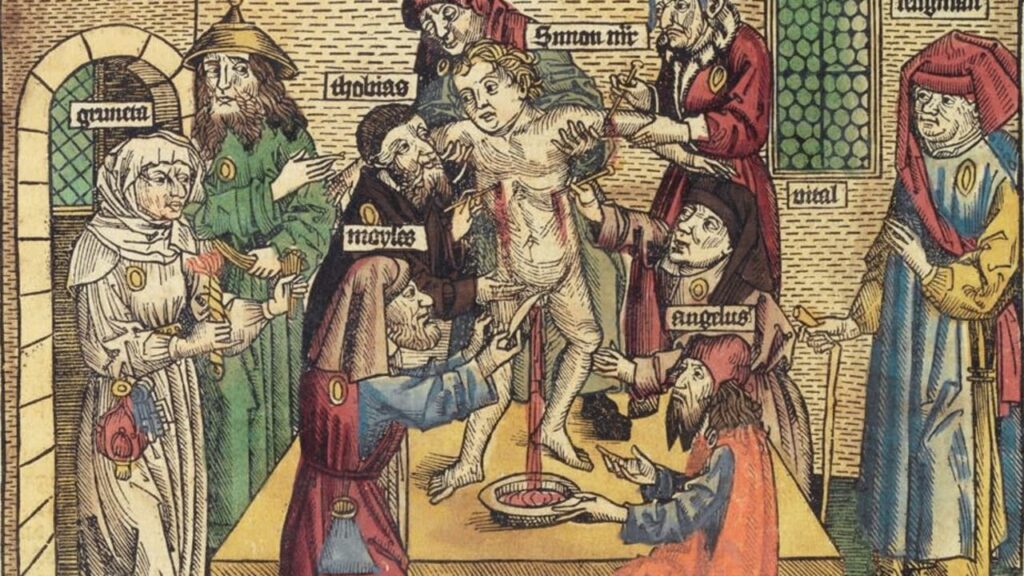 Medieval woodcut-style scene: a naked man is bound to a column on a raised platform while robed figures surround him, with others gesturing or presenting items; a plate sits on a table in the foreground inside a brick-walled room.