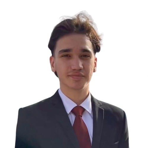 Young man in a black suit with a white shirt and red tie, facing the camera against a white background.