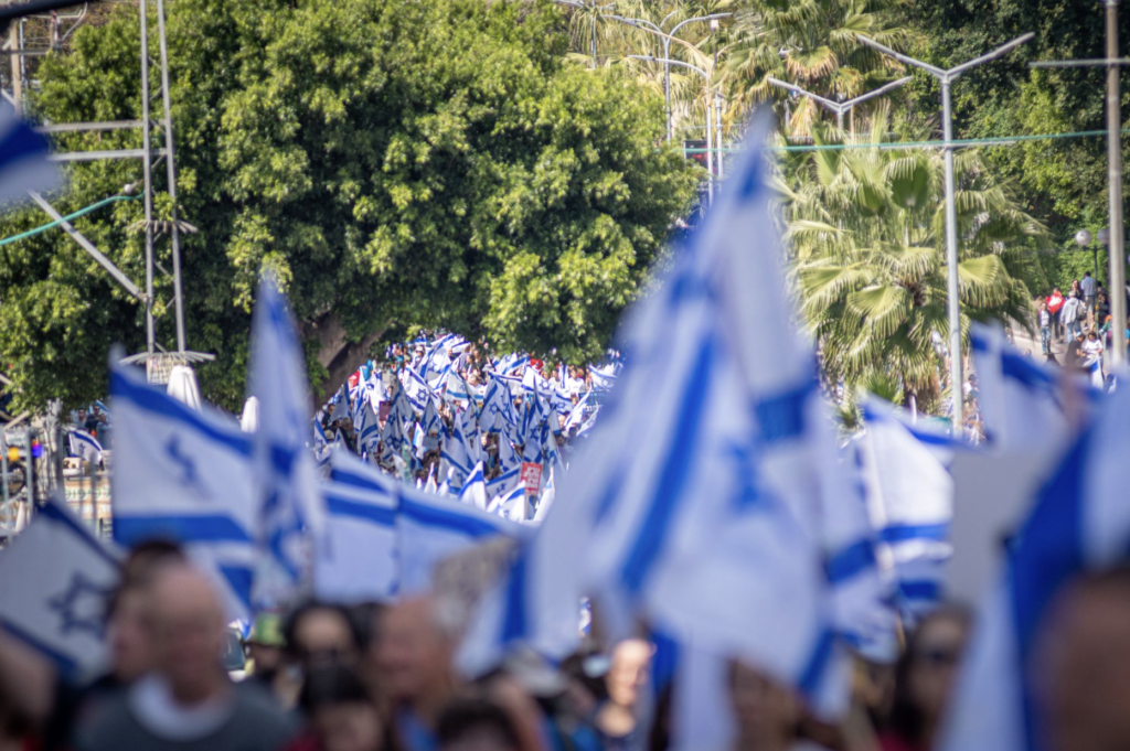 Israeli flags outside in a protest march.