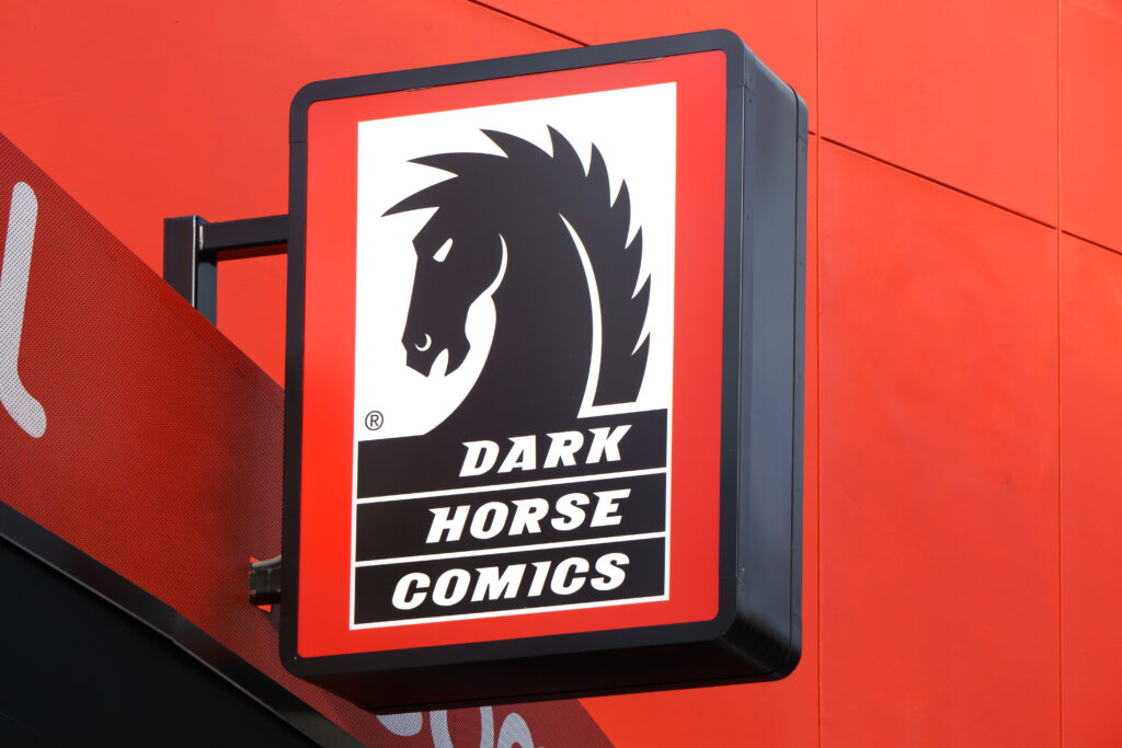 Dark Horse Comics sign: black horse head logo on a white panel framed by a red storefront wall.
