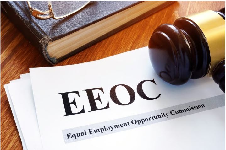 EEOC form on a wooden desk with a gavel and a law book, symbolizing employment law and anti-discrimination.